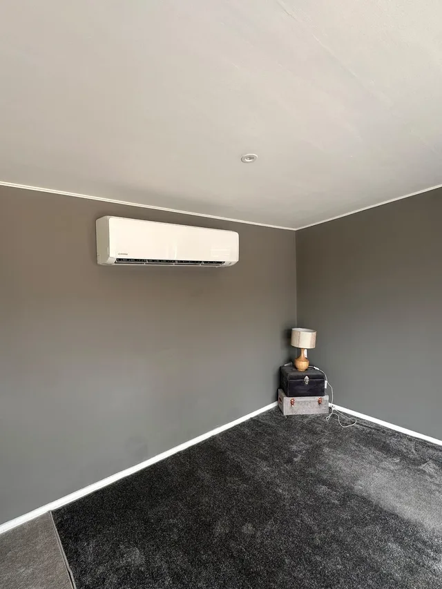 Mitsubishi wall-mounted air conditioning unit in a grey living room